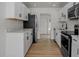 Modern kitchen with white cabinets, stainless steel appliances, and light wood flooring at 4420 Lake Lawne Ave, Orlando, FL 32808