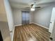 Bedroom with wood floors, ceiling fan, light gray paint, and window with blue drapes at 492 Banyon Tree Cir # 204, Maitland, FL 32751