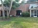 Exterior view of a brick apartment building featuring a landscaped lawn and covered entrances at 492 Banyon Tree Cir # 204, Maitland, FL 32751