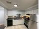 Bright kitchen features white cabinets, neutral countertops, stainless steel appliances and tile floors at 492 Banyon Tree Cir # 204, Maitland, FL 32751