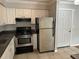Kitchen features white cabinets, neutral countertops, stainless steel appliances and tile floors at 492 Banyon Tree Cir # 204, Maitland, FL 32751
