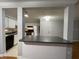 Open kitchen with bar-style seating area, white cabinets, and modern appliances at 492 Banyon Tree Cir # 204, Maitland, FL 32751