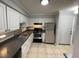 This kitchen features white cabinets, neutral countertops, stainless steel appliances and tile floors at 492 Banyon Tree Cir # 204, Maitland, FL 32751
