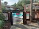 Community pool area with a secure gate, surrounded by lush landscaping and multi-story brick apartment buildings at 492 Banyon Tree Cir # 204, Maitland, FL 32751