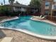 Serene community pool surrounded by brick buildings and furnished with lounge chairs at 492 Banyon Tree Cir # 204, Maitland, FL 32751