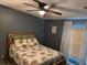 Cozy bedroom featuring a ceiling fan and comfortable bedding with patterned pillows and comforter at 503 Tivoli Park Dr, Davenport, FL 33897