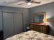 Well-lit bedroom showcasing a dresser with mirror and closet space with a patterned bedspread at 503 Tivoli Park Dr, Davenport, FL 33897