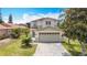 Charming two-story home with a two-car garage, manicured lawn, and updated landscaping at 521 Rena Dr, Davenport, FL 33897