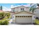A two-story home boasts a two-car garage, a well-manicured lawn, and stylish exterior lighting at 521 Rena Dr, Davenport, FL 33897