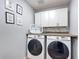 This laundry room features a front loading washer and dryer with built in shelving and framed wall art at 521 Rena Dr, Davenport, FL 33897