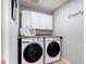 This laundry room features a front loading washer and dryer with built in shelving and a laundry basket at 521 Rena Dr, Davenport, FL 33897