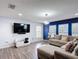 Bright living room with a large TV, comfortable sectional sofa, and ample natural light from the windows at 521 Rena Dr, Davenport, FL 33897