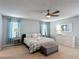 This main bedroom features a ceiling fan, neutral colors, an upholstered ottoman and updated furnishings at 521 Rena Dr, Davenport, FL 33897