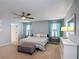 This main bedroom features a ceiling fan, neutral colors, and an upholstered ottoman with updated furnishings at 521 Rena Dr, Davenport, FL 33897