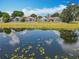 Scenic backyard view featuring a pond and multiple homes with screened lanais at 550 Canary Island Cir, Davenport, FL 33837