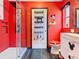 Red bathroom with a glass-enclosed shower and Mickey Mouse decor at 550 Canary Island Cir, Davenport, FL 33837
