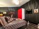 Dark bedroom featuring a large bed with Gucci-themed bedding and black walls at 550 Canary Island Cir, Davenport, FL 33837