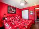 Bedroom with red walls, Disney-themed bedding and chandelier lighting at 550 Canary Island Cir, Davenport, FL 33837