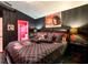 Dark bedroom with black walls and Gucci themed bedding and furnishings at 550 Canary Island Cir, Davenport, FL 33837