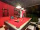 Spacious game room with a red pool table, checkered floor, and a peek at an arcade at 550 Canary Island Cir, Davenport, FL 33837