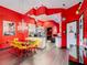 Red kitchen/dining room featuring yellow chairs, chandelier, and gray wood-look floors at 550 Canary Island Cir, Davenport, FL 33837