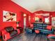 Open concept living room and kitchen featuring red walls and black furniture at 550 Canary Island Cir, Davenport, FL 33837