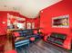 Open concept living room and kitchen with red walls, black furniture, and wood-look floors at 550 Canary Island Cir, Davenport, FL 33837