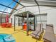 This backyard is designed for outdoor living, featuring an outdoor kitchen and lounge chairs near the screened-in pool at 550 Canary Island Cir, Davenport, FL 33837