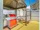 The covered outdoor kitchen has a BBQ grill, counterspace, lighting and lounge seating by the screened-in pool at 550 Canary Island Cir, Davenport, FL 33837