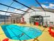 This screened-in pool boasts a spa and outdoor seating with an outdoor kitchen, ideal for relaxation and entertainment at 550 Canary Island Cir, Davenport, FL 33837