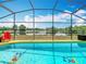 Sparkling screened-in pool area with a view of the golf course at 550 Canary Island Cir, Davenport, FL 33837