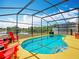 Relax and unwind by the screened-in pool, complete with chairs and lush greenery in the backyard oasis at 550 Canary Island Cir, Davenport, FL 33837