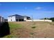 Picture of the house's backyard with partial view of the screen porch and community fencing at 673 Sarner Pass Way, Winter Haven, FL 33881