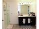 Bathroom with tiled floors, a glass door shower, double sinks and dark vanity at 673 Sarner Pass Way, Winter Haven, FL 33881