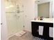 Modern bathroom featuring tiled floors, a glass door shower and dark vanity at 673 Sarner Pass Way, Winter Haven, FL 33881
