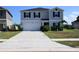 Two-story home showcasing a spacious driveway, two-car garage, manicured lawn, and charming landscaping details at 673 Sarner Pass Way, Winter Haven, FL 33881