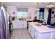 A bright kitchen with stainless steel appliances, white cabinets, an island, and a view through the window at 673 Sarner Pass Way, Winter Haven, FL 33881