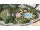 Aerial view of the community pool, lush landscaping, and winding walkways creating a relaxing resort atmosphere at 7509 Mourning Dove Cir # 303, Reunion, FL 34747