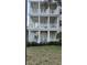 Close-up view of the condo's three-story exterior with spacious, columned balconies and well-kept garden at 7509 Mourning Dove Cir # 303, Reunion, FL 34747