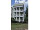 Three story condo building with white balconies and trim over a yellow base near mature landscaping at 7509 Mourning Dove Cir # 303, Reunion, FL 34747