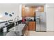 Kitchen with stainless steel appliances, wood cabinets, and granite countertops at 7509 Mourning Dove Cir # 303, Reunion, FL 34747