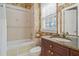 Bathroom featuring a tub and shower, granite vanity, and wallpaper with a tropical pattern at 7550 Gathering Dr, Reunion, FL 34747