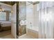 Bathroom featuring a tub with tile surround, floral wallpaper and an open doorway to a bedroom at 7550 Gathering Dr, Reunion, FL 34747