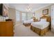 Bright bedroom with two twin beds, a ceiling fan, and a flat-screen TV at 7550 Gathering Dr, Reunion, FL 34747