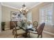Bright dining room with a glass table, chandelier, and large windows with natural light at 7550 Gathering Dr, Reunion, FL 34747