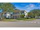 Charming two-story home boasts dual balconies, a manicured lawn, and mature trees at 7550 Gathering Dr, Reunion, FL 34747