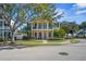 Charming two-story home boasts dual balconies, a manicured lawn, and mature trees at 7550 Gathering Dr, Reunion, FL 34747