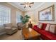 Comfortable living room with a plush red sofa, armchairs, and a large coffee table at 7550 Gathering Dr, Reunion, FL 34747