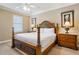 Well-lit bedroom featuring a wooden bed frame, matching nightstands and neutral decor at 7550 Gathering Dr, Reunion, FL 34747