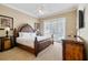 Bedroom featuring a king bed, neutral paint, French doors and wood furniture at 7550 Gathering Dr, Reunion, FL 34747